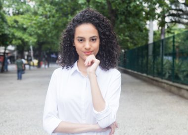 Gülümseyen bir parkta kıvırcık saçlı Karayip kadın