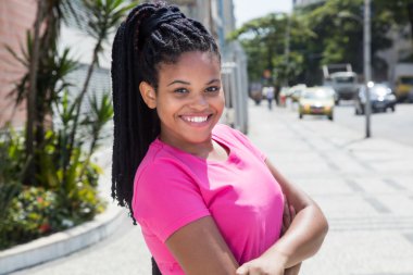 Pembe gömlekli gülen latin kadın