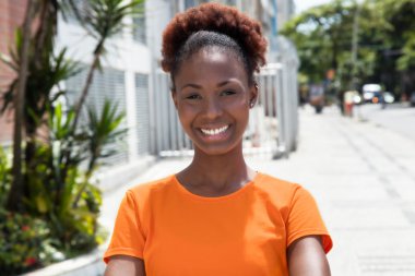 Beautiful african woman in a orange shirt clipart
