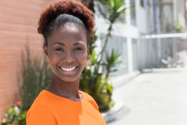 Riendo mujer africana en una camisa naranja — Foto de Stock