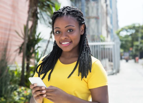 African american kobieta w żółtą koszulkę pisania wiadomości z mob Obrazy Stockowe bez tantiem