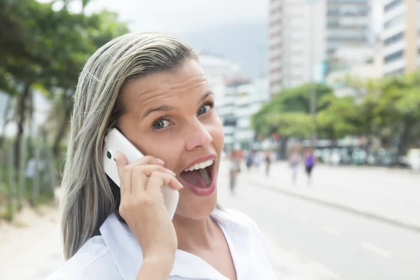 Modische Frau mit blonden Haaren am Telefon in der Stadt — Stockfoto