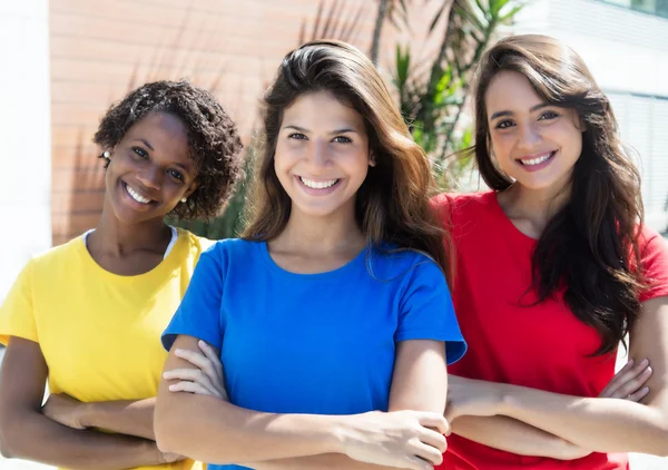 Three happy girlfriends in colorful shirts — Stock Photo, Image