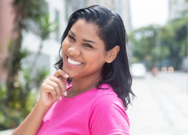 Inheemse Latijns-vrouw lachen in een roze shirt in stad — Stockfoto