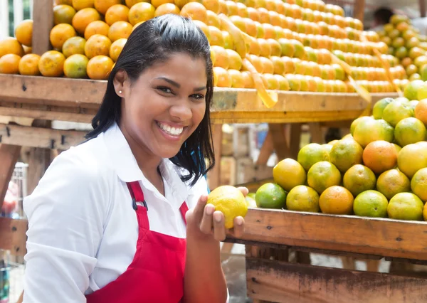 Vendedora mexicana ofreciendo naranjas en un mercado de agricultores — Foto de Stock