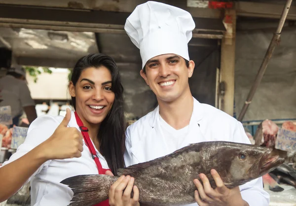 Kock och expediten med färsk fisk på en marknad — Stockfoto
