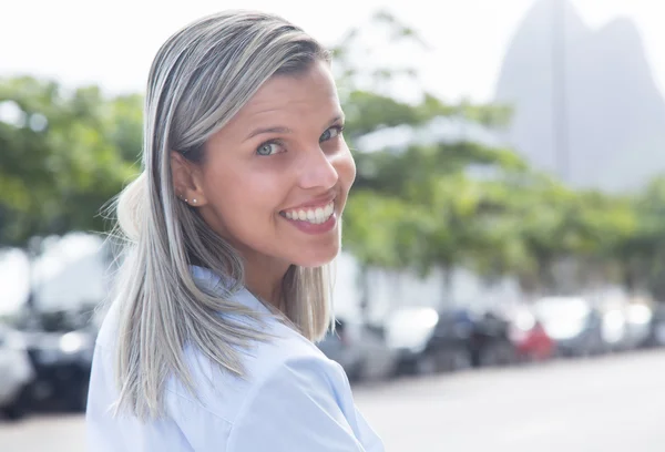 Kaukasische vrouw met blauwe blouse in de stad rondkijken — Stockfoto