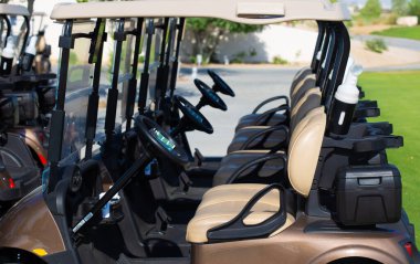 Golf arabası golf sahasında yeşil alan ve bulutlu mavi gökyüzü. Taze çimenler ve ağaçlarla dolu bahar manzarası. Canlı renkler