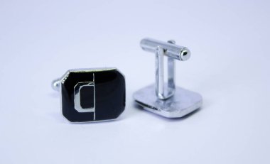 Beyaz arka planda gümüş kol düğmeleri, yakın çekim. Bir çift kol düğmesi, paslanmaz çelik kol düğmeleri.