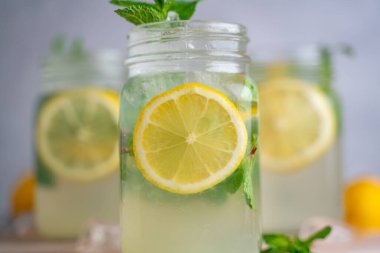 Üç limonlu mojito kokteyli, üzerinde nane şekeri ve ahşap kavanozlar..