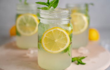 Üç limonlu mojito kokteyli, üzerinde nane şekeri ve ahşap kavanozlar..
