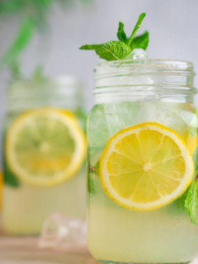 Üç limonlu mojito kokteyli, üzerinde nane şekeri ve ahşap kavanozlar..