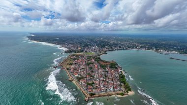 Galle, Sri Lanka, 3 Kasım 2025: Galle şehrinin tarihi Galle Kalesi, deniz feneri, kıyı şeridi ve Hint Okyanusu 'nun turkuaz sularından oluşan insansız hava aracı görüntüsü.