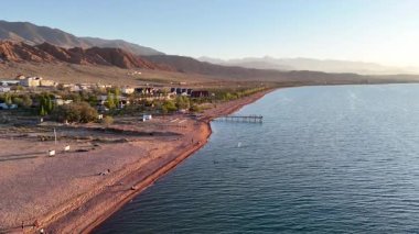 Issyk-Kul, Kırgızistan 25 Ekim 2025: Güneş batarken Issyk-Kul Gölü 'nün çarpıcı insansız hava aracı görüntüsü
