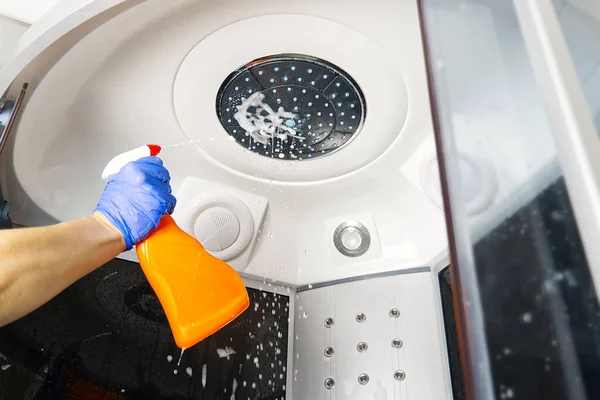 Cleaning of shower steam cabins from calcium deposits. Cleaning in the bathroom. hand in gloves with rag and detergent washing shower and glass — Stock Photo, Image