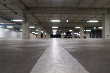 Yumuşak odaklı boş bir park yeri. Boş otopark maviye boyandı. Akşam alışveriş merkezindeki park yerinde.,