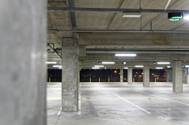 Boş bir park yeri ve hafif odaklı. Boş otopark bulanıklaştı. Akşam alışveriş merkezindeki yeraltı otoparkında.,