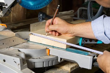 Marangoz işi konsepti. Marangoz ahşap çubuk kesmek için testereyle çalışıyormuş. Parmaklıkları, inşaatı ve tadilatı kesiyormuş..