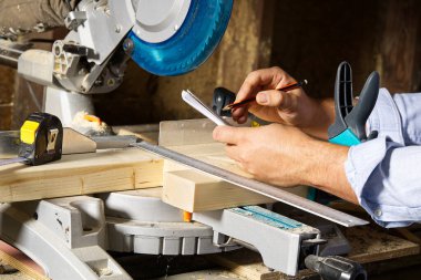 Marangoz işi konsepti. Marangoz ahşap çubuk kesmek için testereyle çalışıyormuş. Parmaklıkları, inşaatı ve tadilatı kesiyormuş..