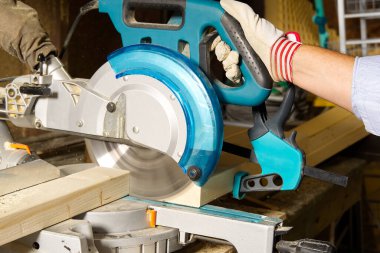 Marangoz işi konsepti. Marangoz ahşap çubuk kesmek için testereyle çalışıyormuş. Parmaklıkları, inşaatı ve tadilatı kesiyormuş..