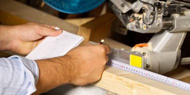 Marangoz işi konsepti. Marangoz ahşap çubuk kesmek için testereyle çalışıyormuş. Parmaklıkları, inşaatı ve tadilatı kesiyormuş..