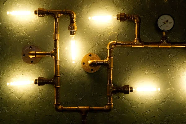 Modern led light made from water pipes. Rustic design, stucco wall with light bulbs and pipes. construction waste recycling concept