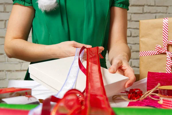女人选择用彩带包装礼物。圣诞和新年的礼物包很暗。手工制作. — 图库照片