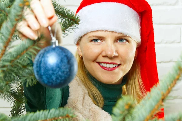 Szőke csinos nő díszítő karácsonyfa kék díszek dekoráció labdák. — Stock Fotó
