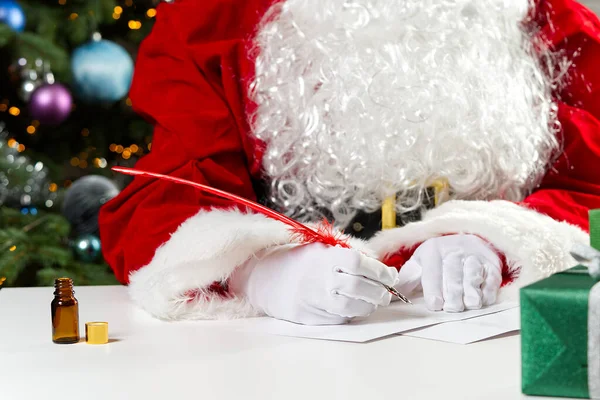 Manos disfrazadas de Santa Claus escribiendo una carta de Navidad o un saludo en una postal. de cerca — Foto de Stock