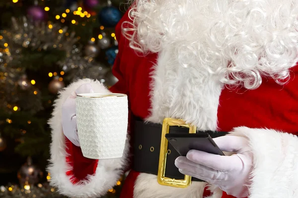 Weihnachtsmann mit weißem Becher mit Kaffee in der Hand, Nahaufnahme. — Stockfoto