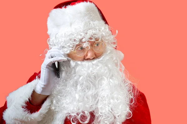 Weihnachtsmann mit Handy isoliert auf rosa Hintergrund — Stockfoto