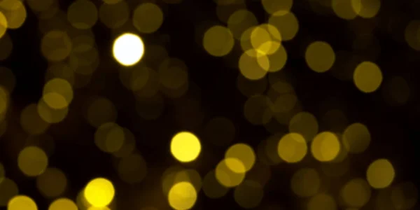 Обезглавленные золотые рождественские огни на темном фоне. желтые круги боке на черном фоне, рождественский фон — стоковое фото
