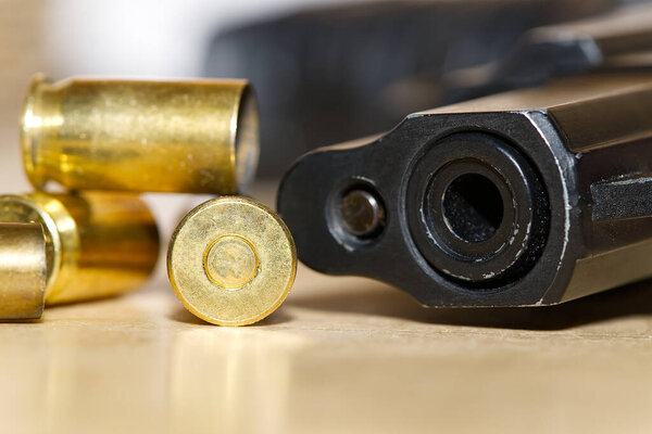 гильзы и ствол пистолета крупным планом на деревянном столе в тире или на месте преступления. преступление концепция