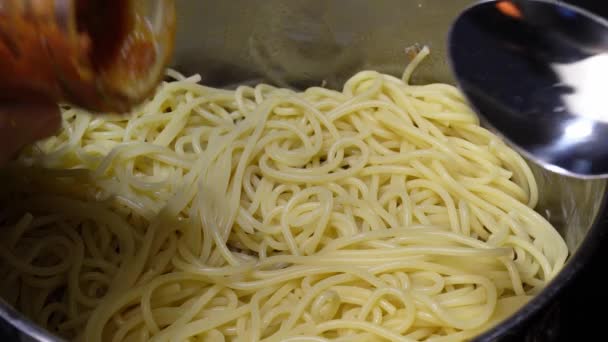 鍋にスパゲティにボロネーゼソースを追加します。家庭でパスタボロネーゼを調理する — ストック動画