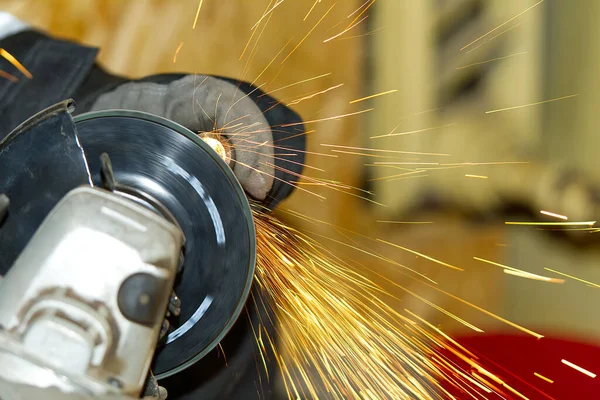 Працівник робить металеві сталеві труби шліфування, крупним планом багато іскр — стокове фото
