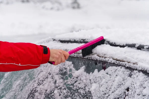 Man schoonmaken van sneeuw van auto voorruit met borstel in de winter ochtend. vervoer, winter, weer. — Stockfoto