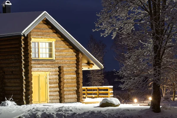 Wooden log cabin at winter night. Country house in winter evening can be used as postcard, wallpaper or poster — Stock Photo, Image