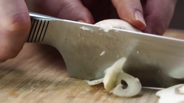 女人们的手正在黑暗的厨房桌子上用一把小刀切割香喷枪.煮蘑菇菜的概念. — 图库视频影像