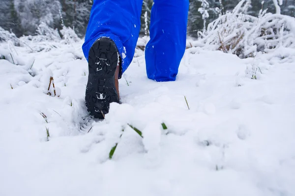 Uomo escursioni nella foresta invernale con la neve in scarpe da trekking stivali. Escursioni invernali. — Foto Stock