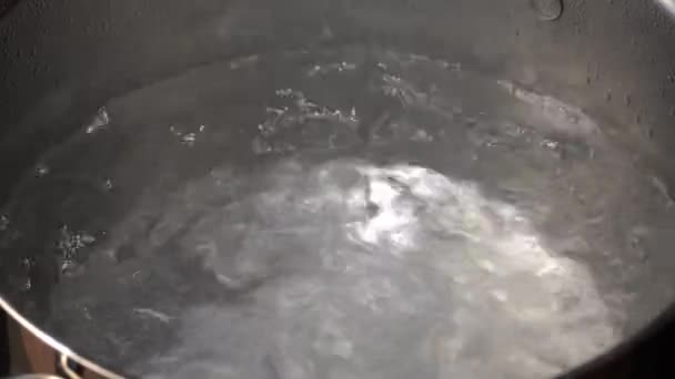 Fermer l'eau chaude bouillante avec beaucoup de bulles sur un alambic d'une casserole grise argentée. — Video