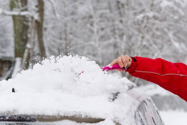 Adam kış sabahı arabasının ön camından kar temizliyor. ulaşım, kış, hava.