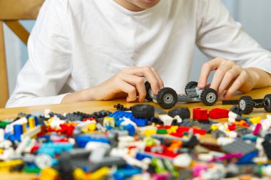 Genç çocuk evde plastik inşaat oyuncaklarıyla oynuyor..