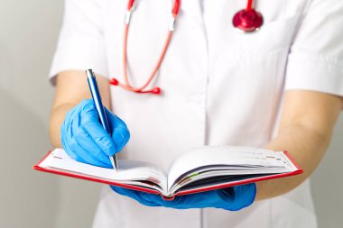 Doktor kırmızı günlüğe not alır.