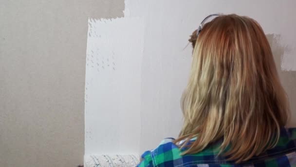 Woman with painting roller and white paint coloring drywall — Stock Footage Woman with painting roller and white paint coloring drywall Video Clip