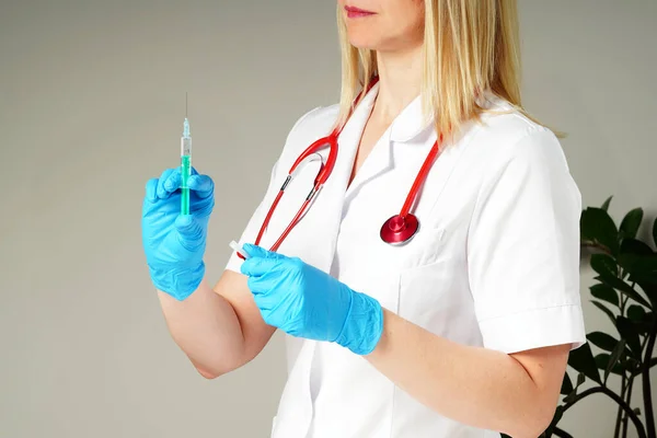 Arts handen injecteert een injectienaald in een flesje met een vaccin of medicijn wijst virus of griep toe. — Stockfoto