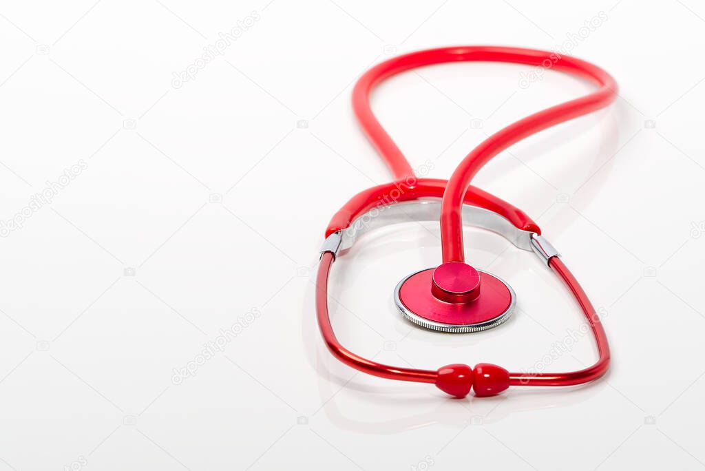 Red stethoscope on white background, close up