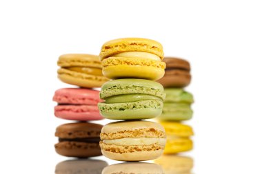 Makarna. Geleneksel Fransız renkli badem kurabiyeleri kapanıyor. Beyaz arkaplanda izole edilmiş sütunlar halinde Macro badem kurabiyeleri