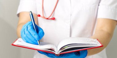 Doktor kırmızı günlüğe notlar alır.