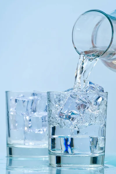 A deitar água. verter água potável de um decantador de vidro para vidro. — Fotografia de Stock