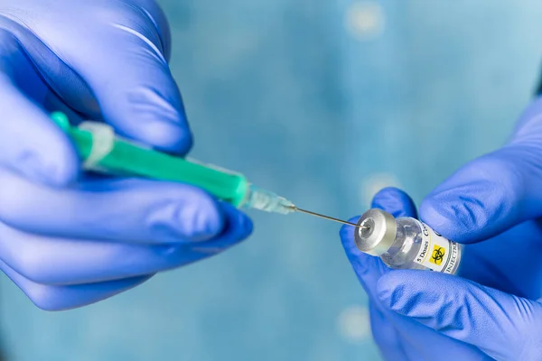 Läkaren slår in vaccinet i en spruta. en sjuksköterska med ett vaccin och en spruta i händerna — Stockfoto